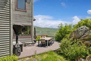 View of patio / terrace featuring outdoor dining space and a deck with mountain view