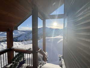 Snow covered deck with a mountain view