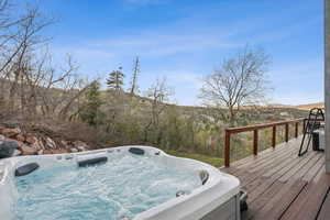 Wooden deck featuring a hot tub and a mountain view