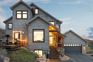 Contemporary home with a porch, aphalt driveway, and stairway