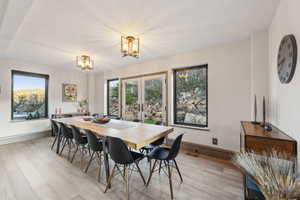 Dining area featuring light wood-style floors, an inviting chandelier, visible vents, and french doors