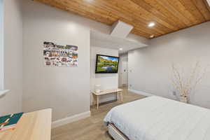 Bedroom featuring wood ceiling, light wood-style flooring, baseboards, and recessed lighting