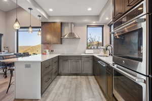 Kitchen with a peninsula, light wood-type flooring, a sink, and a breakfast bar area