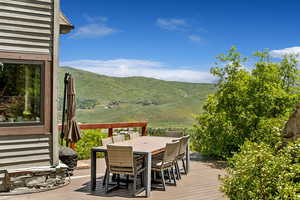 Wooden terrace featuring outdoor dining area and a mountain view