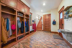Mudroom with brick floor, baseboards, and recessed lighting