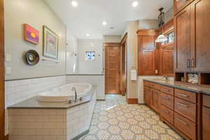 Full bathroom with vanity, visible vents, tile patterned floors, a garden tub, and tiled shower