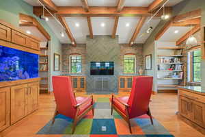 Living area with light wood-style flooring, brick wall, and plenty of natural light