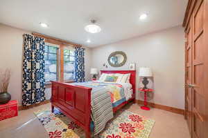 Bedroom featuring baseboards, recessed lighting, and light colored carpet