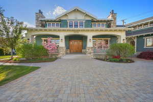 Craftsman house with covered porch, decorative driveway, and a chimney