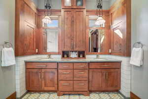 Bathroom featuring double vanity, baseboards, and a sink