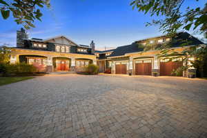 View of front of property with stone siding, decorative driveway, a chimney, and french doors