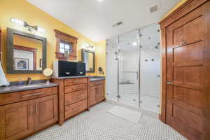 Bathroom featuring a stall shower, vanity, and visible vents