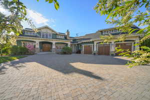View of front of house featuring a garage, stone siding, and driveway