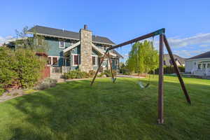 Rear view of house featuring a yard and a chimney