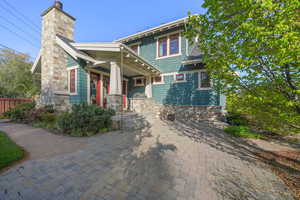 View of front facade featuring a chimney and fence