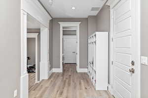 Interior space featuring baseboards, light wood-type flooring, visible vents, and recessed lighting