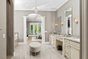 Bathroom with recessed lighting, coffered ceiling, ornamental molding, decorative columns, and a bathing tub
