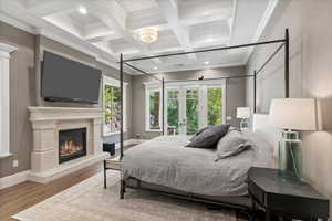 Bedroom featuring french doors, wood finished floors, coffered ceiling, beam ceiling, and baseboards