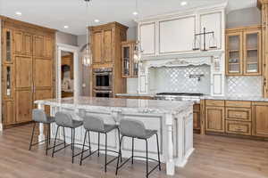 Kitchen with a center island, stainless steel appliances, tasteful backsplash, and brown cabinetry