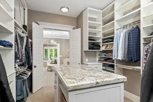 Walk in closet featuring light colored carpet