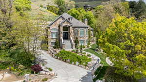 View of front of property featuring stone siding, stairway, and a chimney