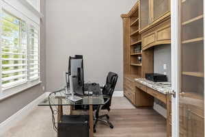 Office area with light wood-style flooring, a wealth of natural light, and baseboards