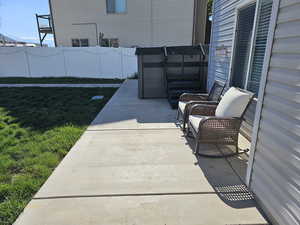 View of patio featuring a hot tub and fence