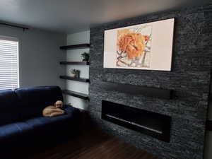 Living area with dark wood-style flooring and a fireplace
