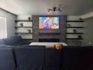 Living room featuring a fireplace, visible vents, and a textured ceiling