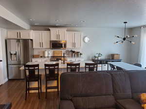Living area featuring recessed lighting, an inviting chandelier, and dark wood-style floors