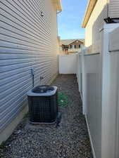 View of property exterior with central AC and fence