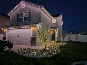 View of front of home featuring fence, driveway, a garage, stucco siding, and a lawn