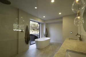 Bathroom with a sink, a freestanding bath, double vanity, and recessed lighting