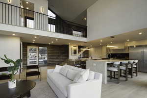 Living room with log walls, high vaulted ceiling, a healthy amount of sunlight, and stairs
