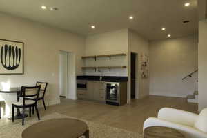 Living area with wine cooler, recessed lighting, visible vents, wet bar, and light wood-type flooring