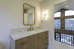 Bathroom featuring vanity and high vaulted ceiling