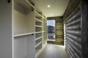 Walk in closet with hardwood / wood-style floors