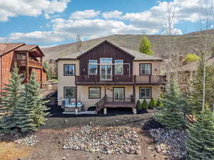 Back of house with a deck, a patio, stucco siding, and french doors