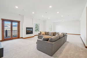 Living room with baseboards, a healthy amount of sunlight, recessed lighting, and light colored carpet