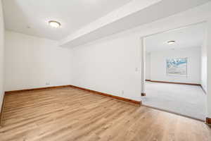 Empty room featuring baseboards and light wood finished floors