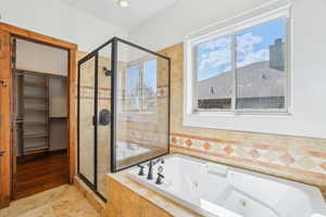 Full bathroom with a jetted tub and a stall shower