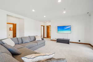 Carpeted living room with baseboards and recessed lighting