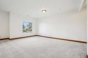 Spare room with light carpet and baseboards