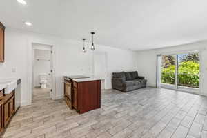 Kitchen with electric range, light countertops, light wood-style floors, dishwasher, and recessed lighting