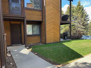 Doorway to property with a balcony and a yard