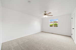 Unfurnished bedroom with light carpet, baseboards, visible vents, and ceiling fan
