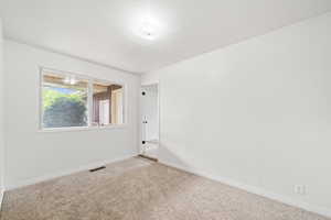 Spare room with baseboards, visible vents, and carpet floors