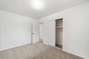 Unfurnished bedroom with a closet, baseboards, and carpet floors