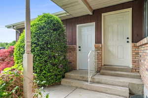 View of exterior entry with brick siding