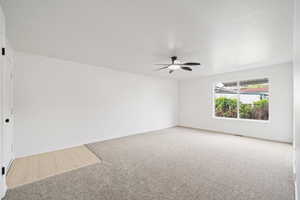 Carpeted empty room with baseboards and a ceiling fan